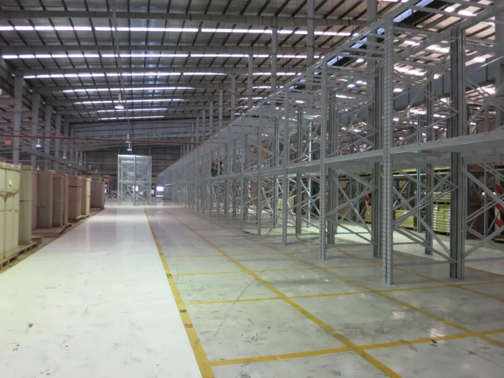 Lối đi hẹp giữa hai dãy kệ pallet cao trong nhà kho thông thủy lớn