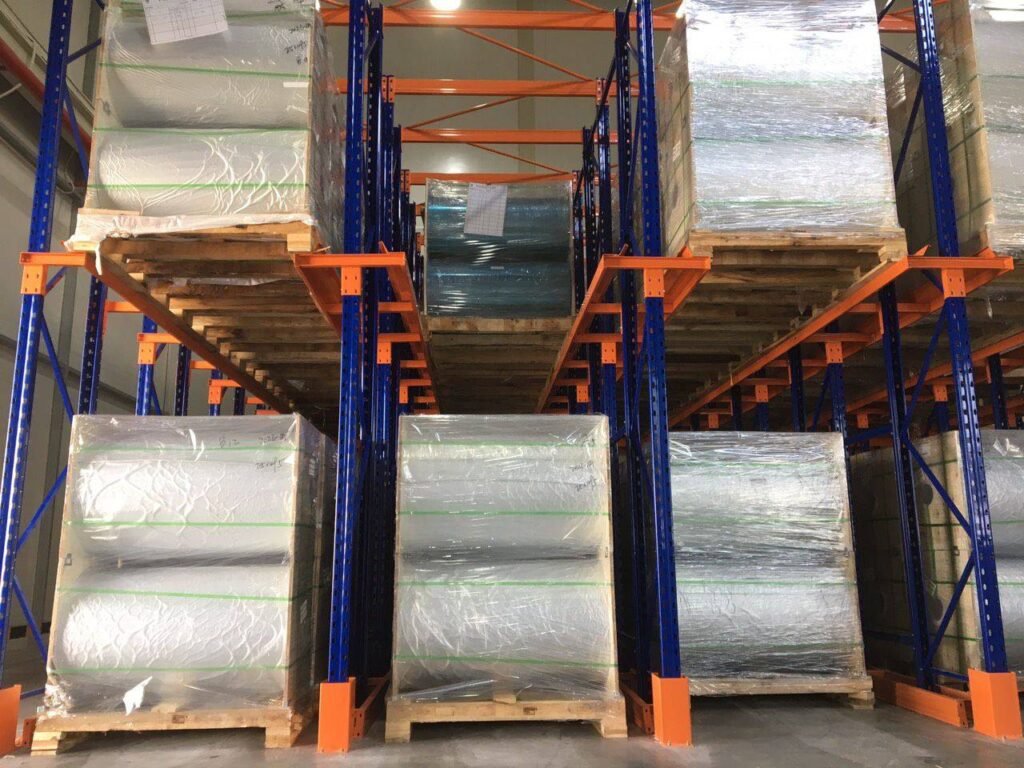 Xe nâng vận hành trong lối đi giữa các dãy kệ pallet